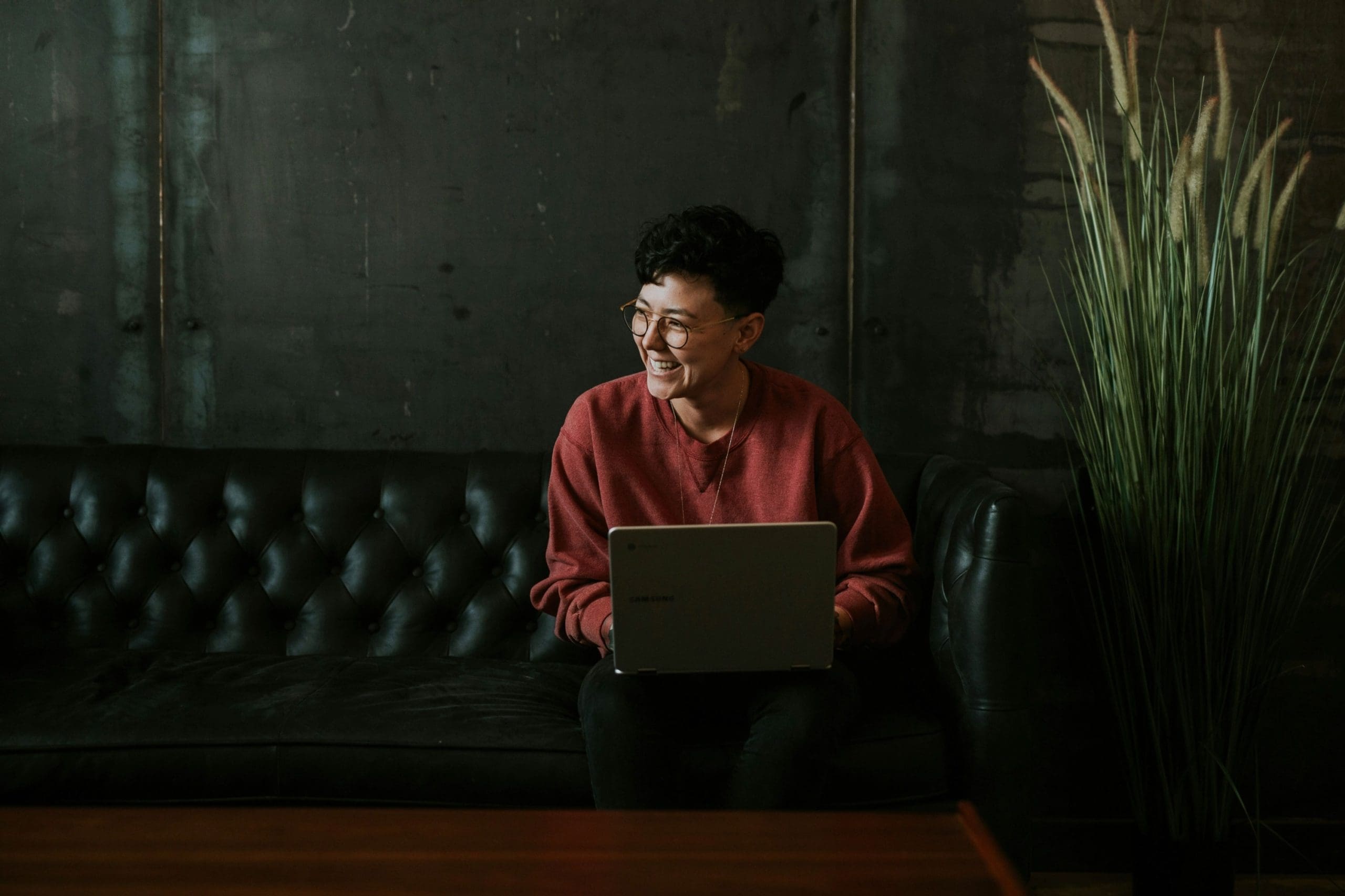 Person sitting on laptop, smiling