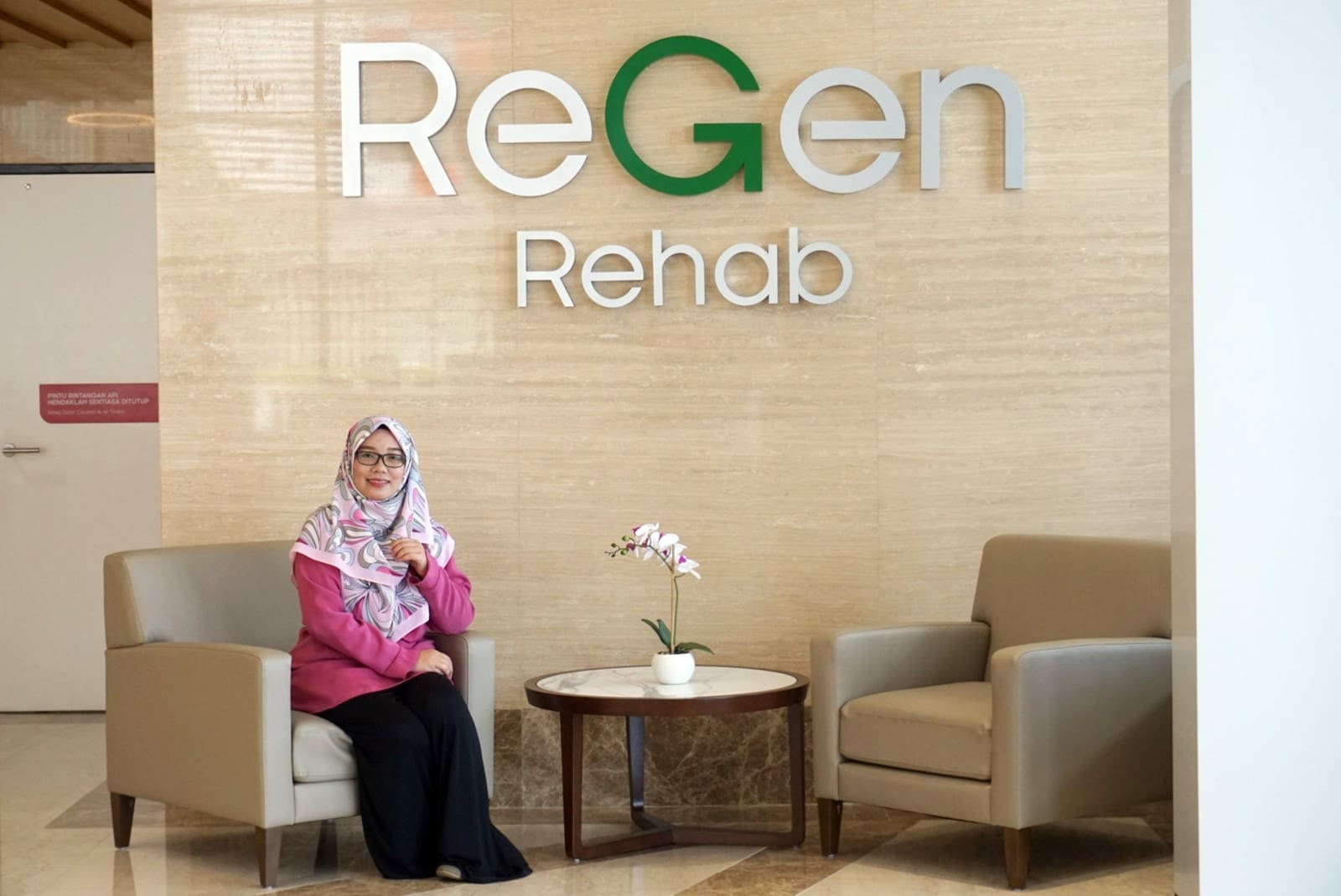 ReGen patient waits on a waiting room below the ReGen rehab centre logo.