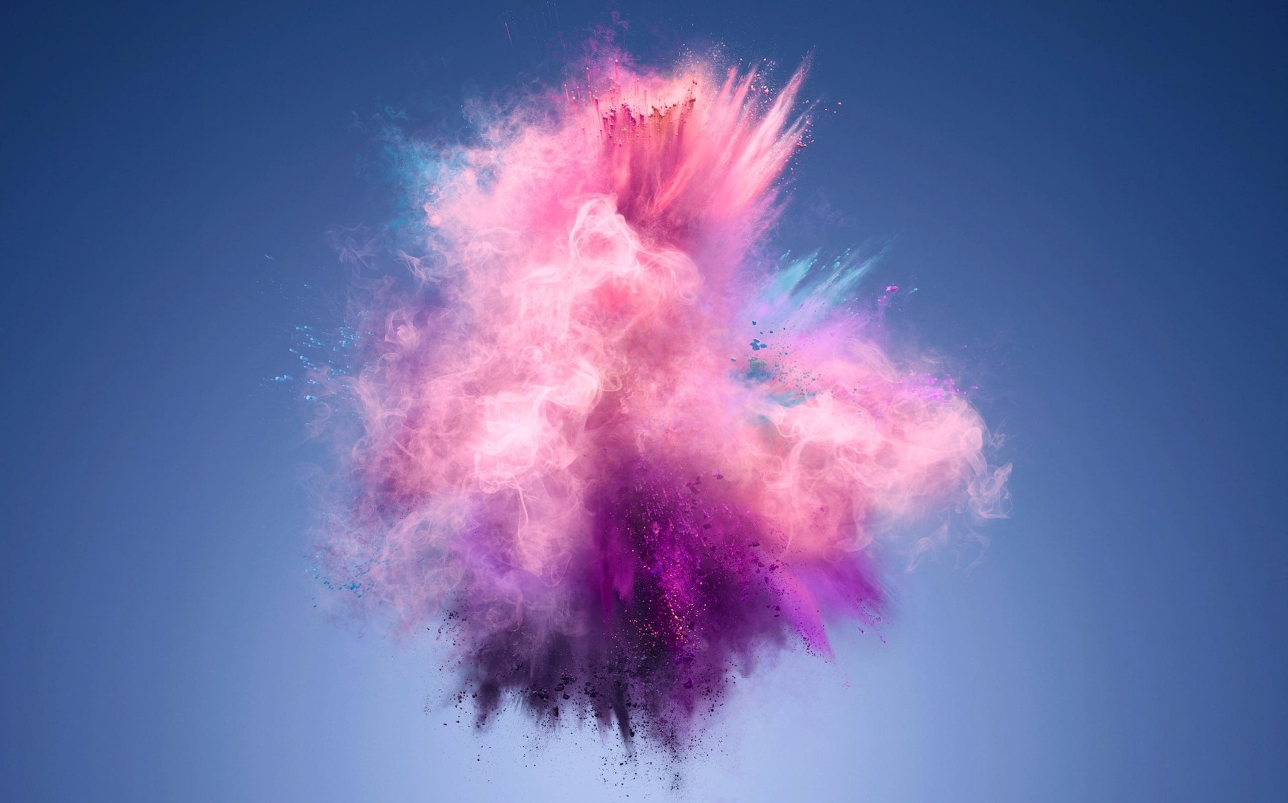 Explosion of vibrant pink, purple, and blue powder clouds against a clear blue background.