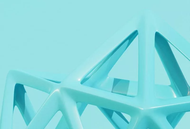 Close-up of a glossy turquoise geometric structure against a matching turquoise background.