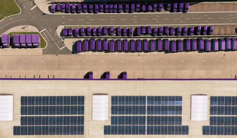 Aerial view of a fishing boat casting large green nets in the ocean.