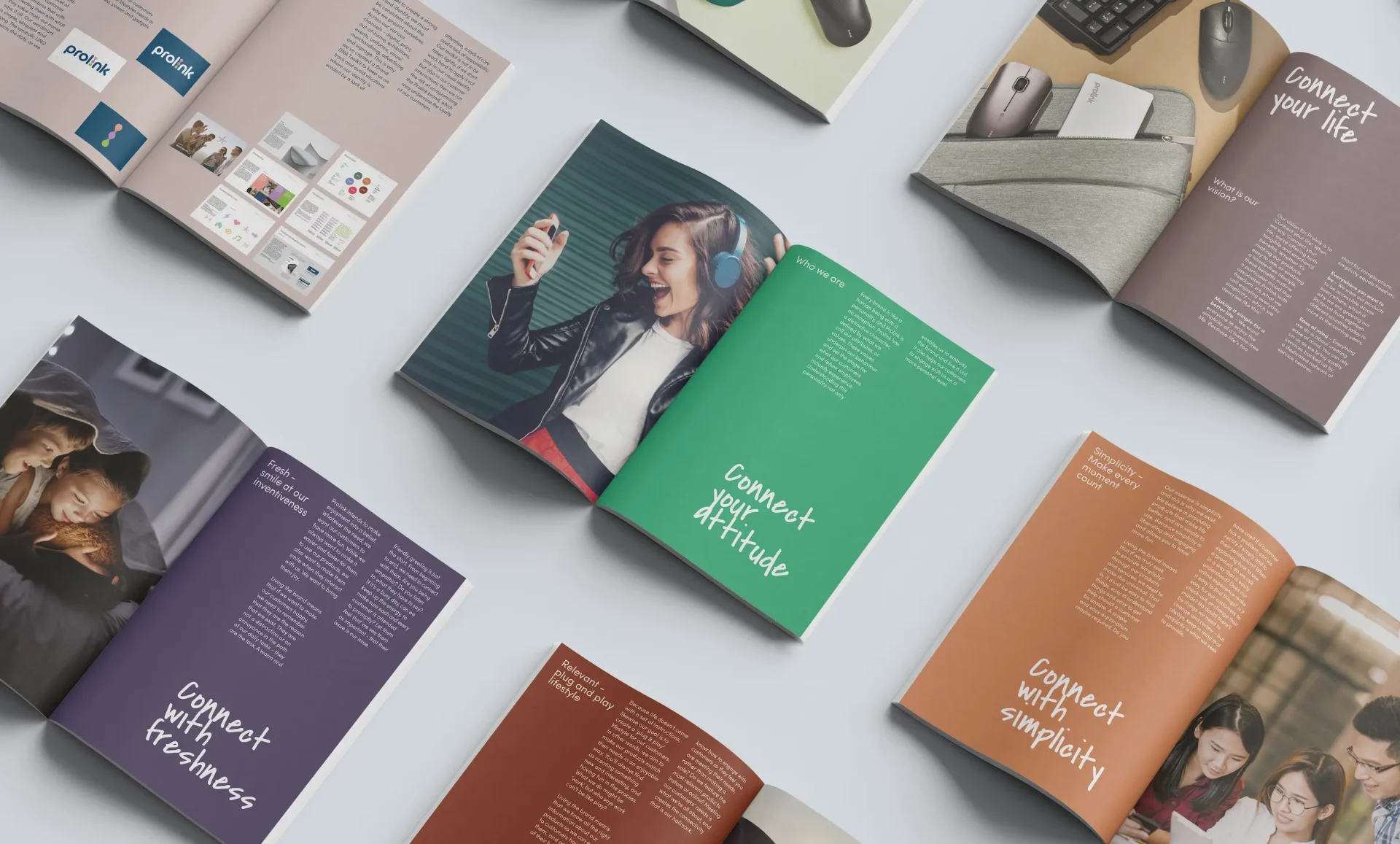 Overhead view of multiple open brand magazines arranged on a light surface. The spreads feature lifestyle photography, colorful layouts, and handwritten-style slogans such as “Connect your attitude,” “Connect with freshness,” and “Connect with simplicity,” presenting a cohesive, modern brand identity.